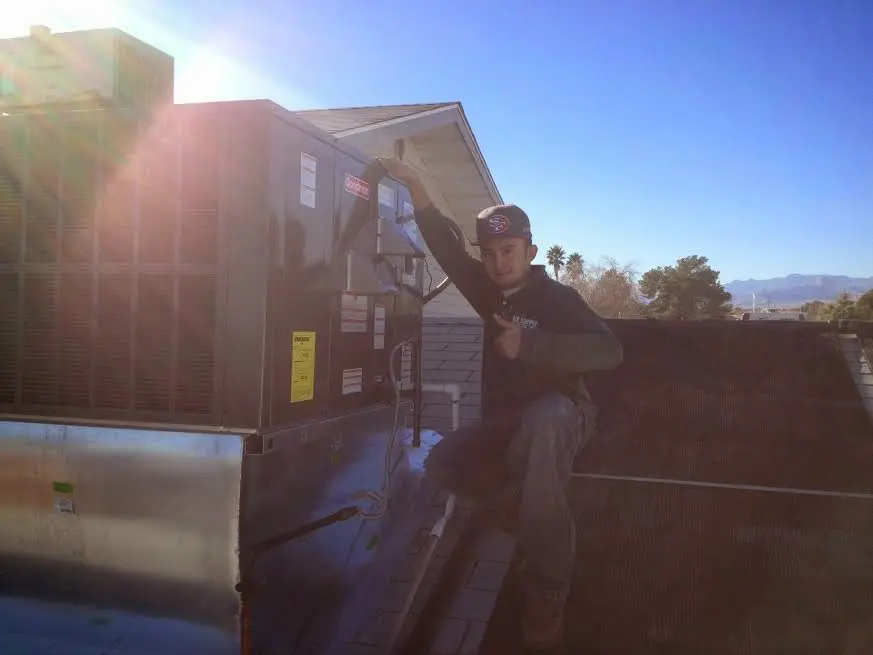 HVAC technician performing HVAC Inspection on a rooftop unit in Guntersville